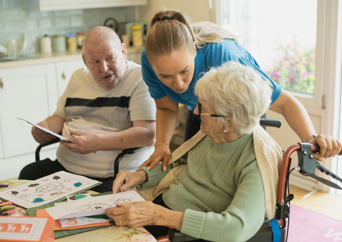 Carer supporting older people with an activity