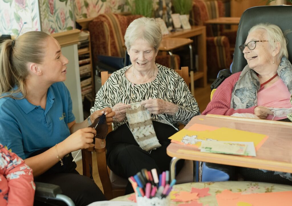 Care worker helping clients with a craft activity